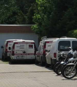 Zwei beschriftete Servicefahrzeuge der Hans Heymann GmbH auf dem eigenen Betriebsgelände
